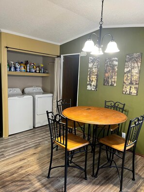A compact kitchen with a washing machine, a drying rack, and a shelf with cleaning supplies. - Camp / 1097 Elm run (St. Martin Parish)