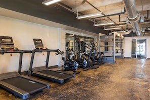 A gym with treadmills, elliptical machines, and weightlifting equipment. - Landing | Amazing 1BD, Gym, Rooftop Lounge (Jacksonville)