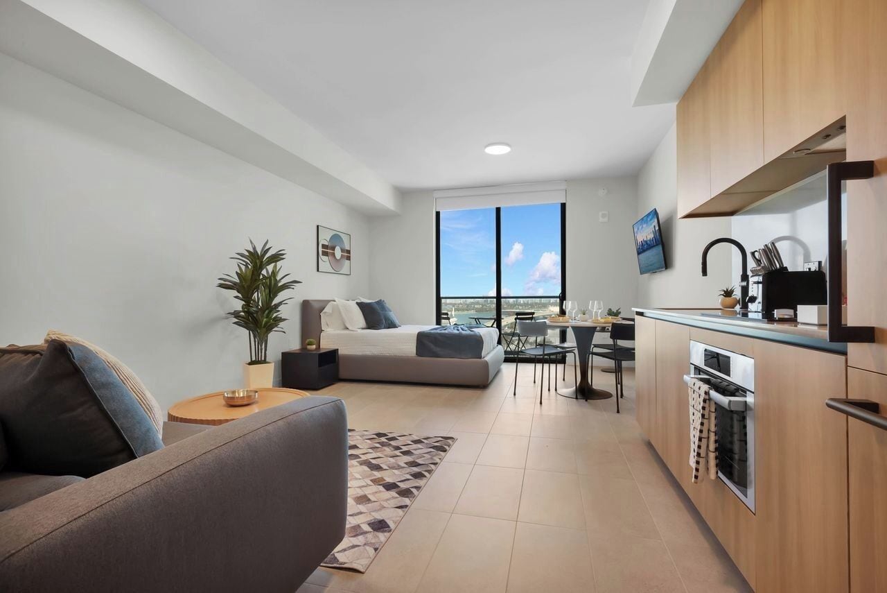 Um apartamento moderno com sala de estar, espaço para refeições e cozinha compacta.
