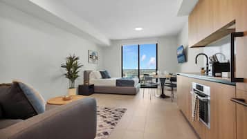 Um apartamento moderno com sala de estar, espaço para refeições e cozinha compacta.