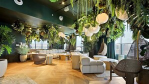 A modern lounge area with a variety of seating options, including sofas and chairs, arranged around a central coffee table. - Miami Luxe Suites (Miami)