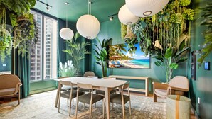 A room with a dining table, chairs, a sofa, a TV, and a large window. - Miami Luxe Suites (Miami)