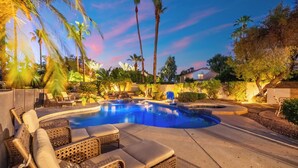 A swimming pool with lounge chairs and palm trees. - Luxury 5BR Retreat, Heated Pool, Spa, Sport Court, Putting Green & Game Rooms (Scottsdale)