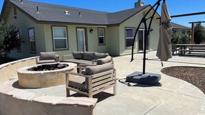A patio area with outdoor furniture, a fire pit, and a covered seating area. - Top of the Hill by Avantstay Vineyard Views + Fire Pit 1 Min to Wine Trail (San Miguel)