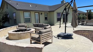 A patio area with outdoor furniture, a fire pit, and a covered seating area. - Top of the Hill by Avantstay Vineyard Views + Fire Pit 1 Min to Wine Trail (San Miguel)