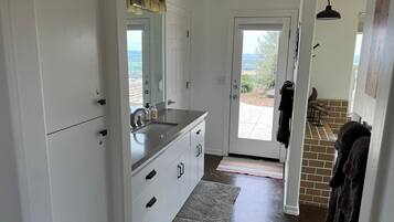 A modern kitchen with a large window, white cabinetry, and a built-in sink.