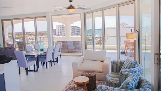 A spacious balcony with a dining area, seating, and a view of the cityscape. - Luxury Beachfront Villa in Sandy Beach - Ocean View - Sleeps 9 Max. Pet-Friendly (Puerto Peñasco)