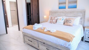 Une chambre d’hôtel avec un lit, une table de chevet, une tête de lit en bois et une porte.