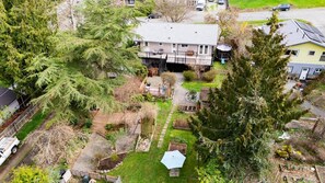 A residential property with a large house, a fenced yard, and a garden area.