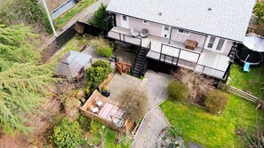 A two-story house with a covered patio, a fenced yard, and a satellite dish.