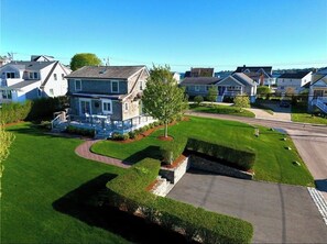 A residential area with houses, a well-maintained lawn, and a driveway.