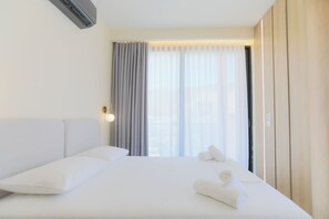 A hotel room with a large bed, a bedside lamp, and a window with curtains. - Seaside Serenity Palm Apartment, Vlore, Albania (Vlore)