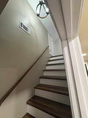 A staircase with wooden steps and a white wall.