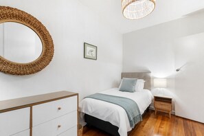 A bedroom with a bed, bedside table, lamp, and a large mirror. - St George's Gate - Toorak by Ready Set Stay (Toorak)
