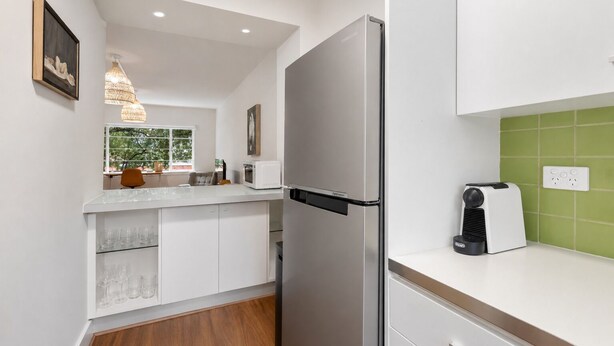 Eine moderne Küche mit einem Edelstahlkühlschrank, einem eingebauten Backofen und einem Toaster.