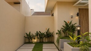 Um espaço ao ar livre moderno com um caminho de concreto, grama verde e diversas plantas.