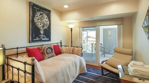 A bedroom with a bed, a chair, a lamp, a poster, and a view of the outdoors. - Peachy Canyon Place by Avantstay Vineyard Deck Views Near Wineries (Paso Robles)