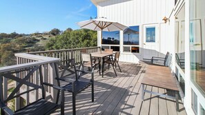 A wooden deck with outdoor furniture, including a table and chairs, and a large umbrella. - Peachy Canyon Place by Avantstay Vineyard Deck Views Near Wineries (Paso Robles)