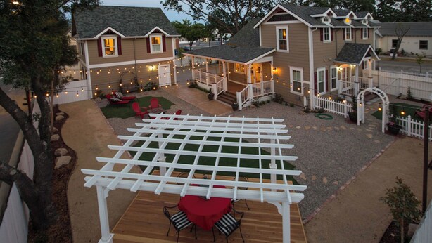 Una proprietà residenziale con patio coperto, posti a sedere all'aperto e luci decorative.