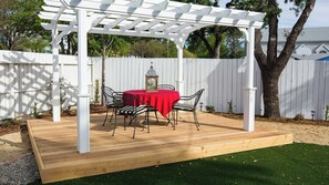 A wooden deck with a pergola, a red table, and four chairs. - Bliss House by Avantstay Victorian Charm + Gazebo Yard + Corn Hole Walk to Dining + Park (Paso Robles)