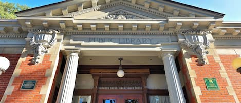 Una biblioteca pública con arquitectura clásica, incluyendo columnas y un frontón con el nombre de la biblioteca.