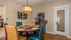 A dining area with a round table, multiple chairs, a hanging light fixture, and wall art. - The Sycamore by Avantstay Fenced Yard + BBQ Walk to Downtown Wineries (Paso Robles)