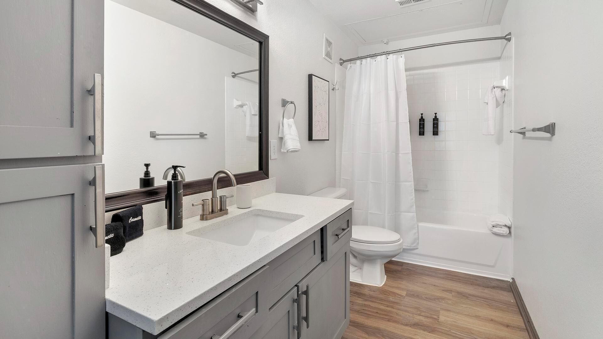 Een moderne badkamer met een dubbele wastafel, toilet en douche.