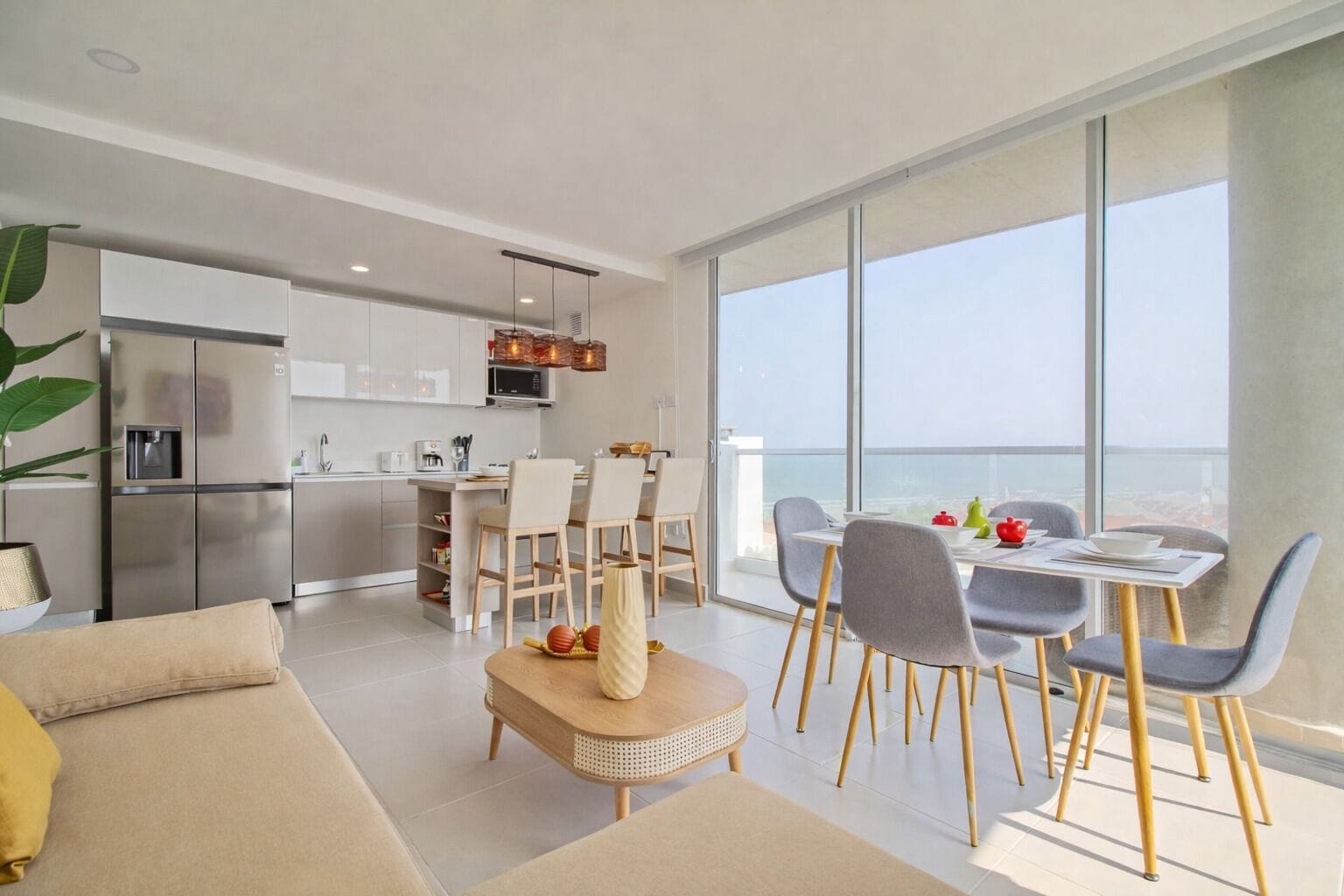 Un appartement moderne comprenant un coin repas, une cuisine et un balcon avec vue.