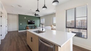 Eine moderne Küche mit Kochinsel, integriertem Geschirrspüler und Deckenventilator.
