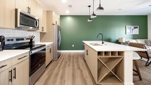A modern kitchen with a built-in microwave, oven, and refrigerator. - Landing | Stunning 1BD, Game Room, Gym (Goodyear)