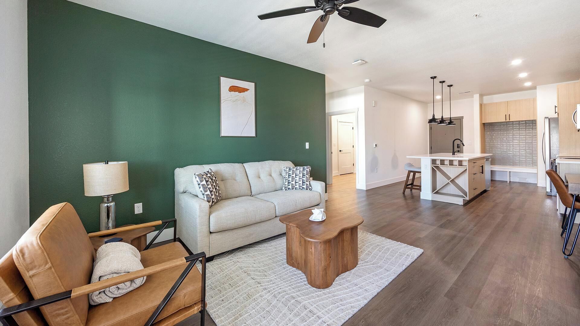A modern living room with a sofa, coffee table, and a ceiling fan.