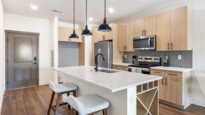 Eine moderne Küche mit einer Kochinsel, Edelstahlgeräten und Holzschränken.