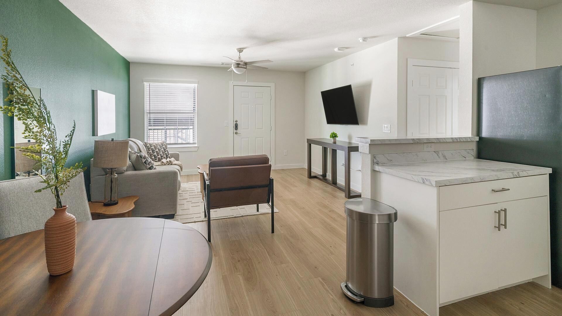 Un appartement moderne comprenant un salon, un coin repas, une cuisine et un balcon.