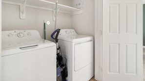 A laundry area with two white washing machines and a hose. - Landing | Beautiful 1BD in Bear Creek (Houston)