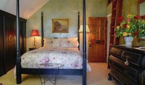 A four-poster bed with a floral bedspread, a wooden wardrobe, a dresser with a vase of flowers, and a painting on the wall. - Orchard Hill Farm by Avantstay Vineyard Views + Fire Pit + BBQ Countryside Wine Country (Paso Robles)