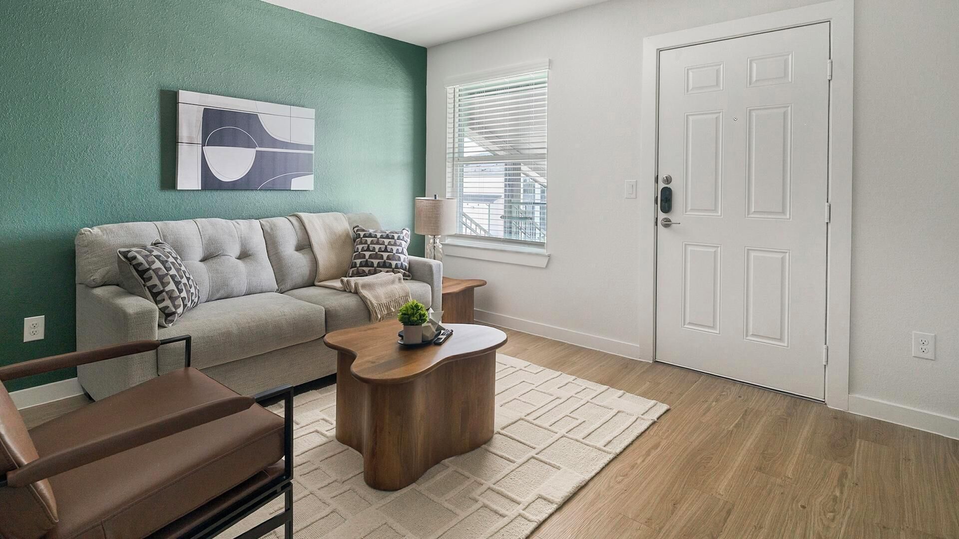 A living room with a sofa, coffee table, and a door.