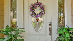 Eine weiße Tür mit Glasfenster, einem Messing-Klopfer und einem Zahlenschloss.