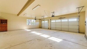 A garage with two double doors, a wooden cabinet, and a sloped ceiling with skylights. - Peace of Mind by Avantstay Fenced BBQ Yard + Game Table Paso Robles (Paso Robles)