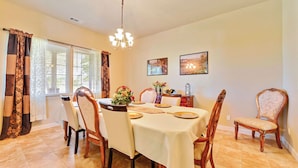 A dining room with a chandelier, floral arrangements, and two framed pictures on the wall. - Peace of Mind by Avantstay Fenced BBQ Yard + Game Table Paso Robles (Paso Robles)