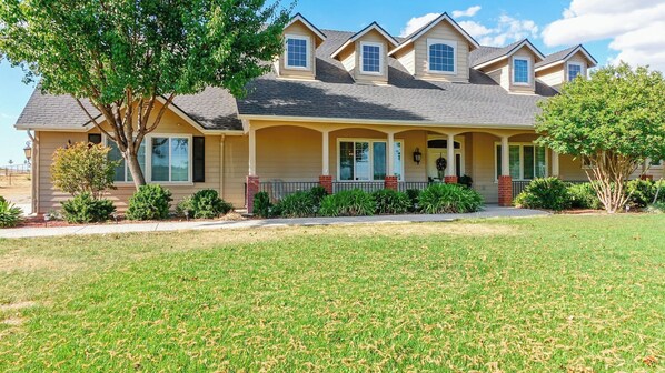 A two-story house with a covered porch, a landscaped front yard, and a tree. - Peace of Mind by Avantstay Fenced BBQ Yard + Game Table Paso Robles (Paso Robles)