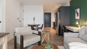 Ein modernes Wohnzimmer mit einer Couch, einem Couchtisch und einem Essbereich mit Stühlen.