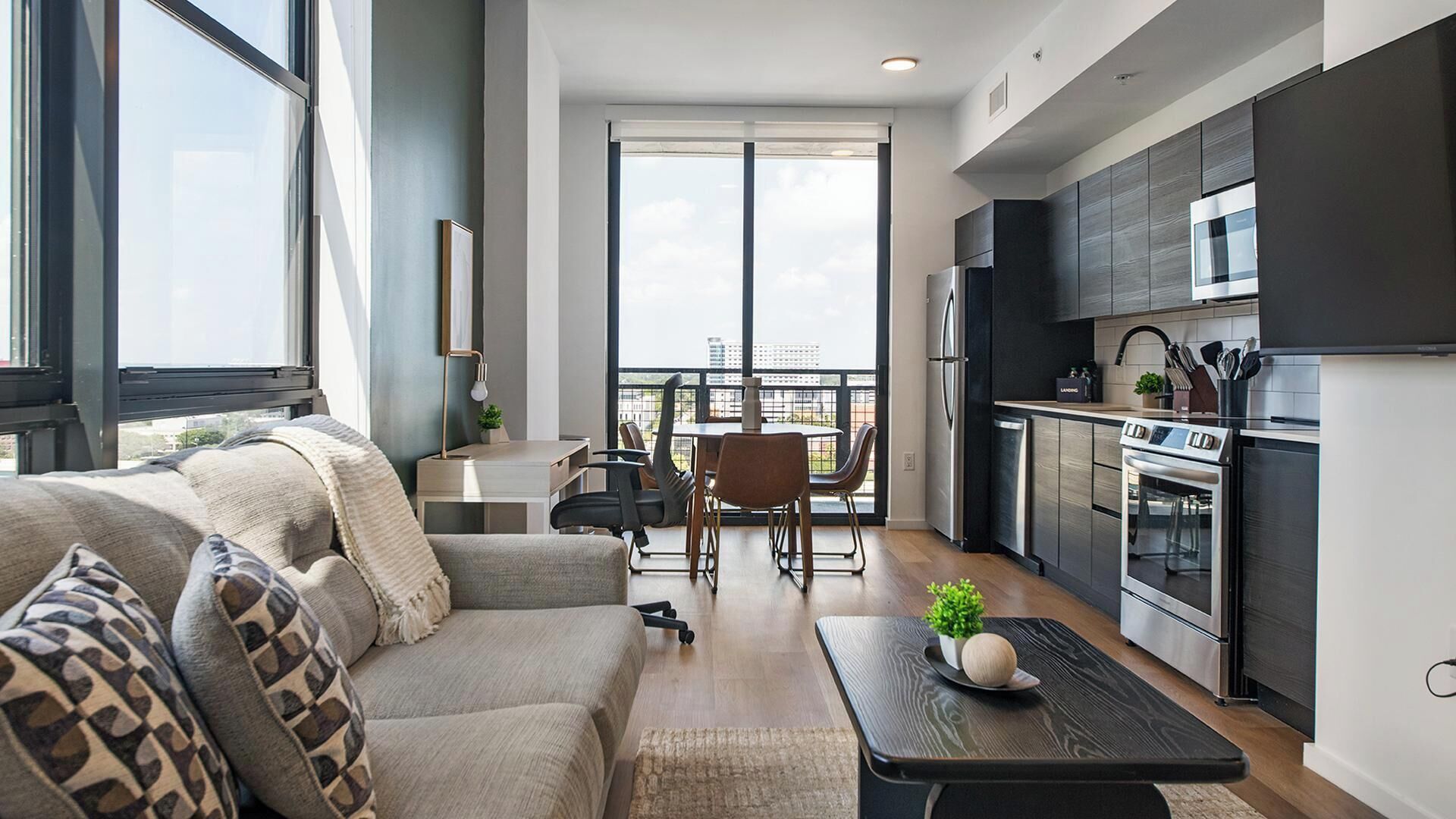 Un appartement moderne comprenant un espace de vie, un coin repas et une cuisine.