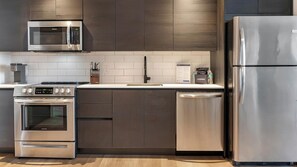 A modern kitchen with stainless steel appliances, a microwave, oven, and dishwasher. - Landing | Amazing 2BD, Pool, Gym (Orlando)