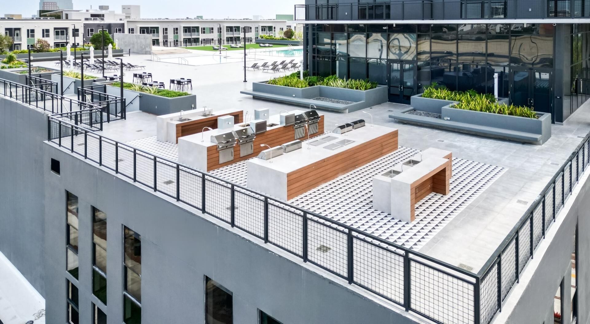 Une terrasse sur le toit avec des sièges extérieurs, une piscine et un bâtiment moderne en arrière-plan.