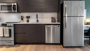 A modern kitchen with stainless steel appliances, a dishwasher, and a microwave. - Landing | Chic Studio, Rooftop Lounge, Courtyard (Orlando)