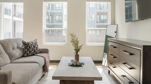 Un salon avec un canapé, une table basse ornée d’un vase et une commode.