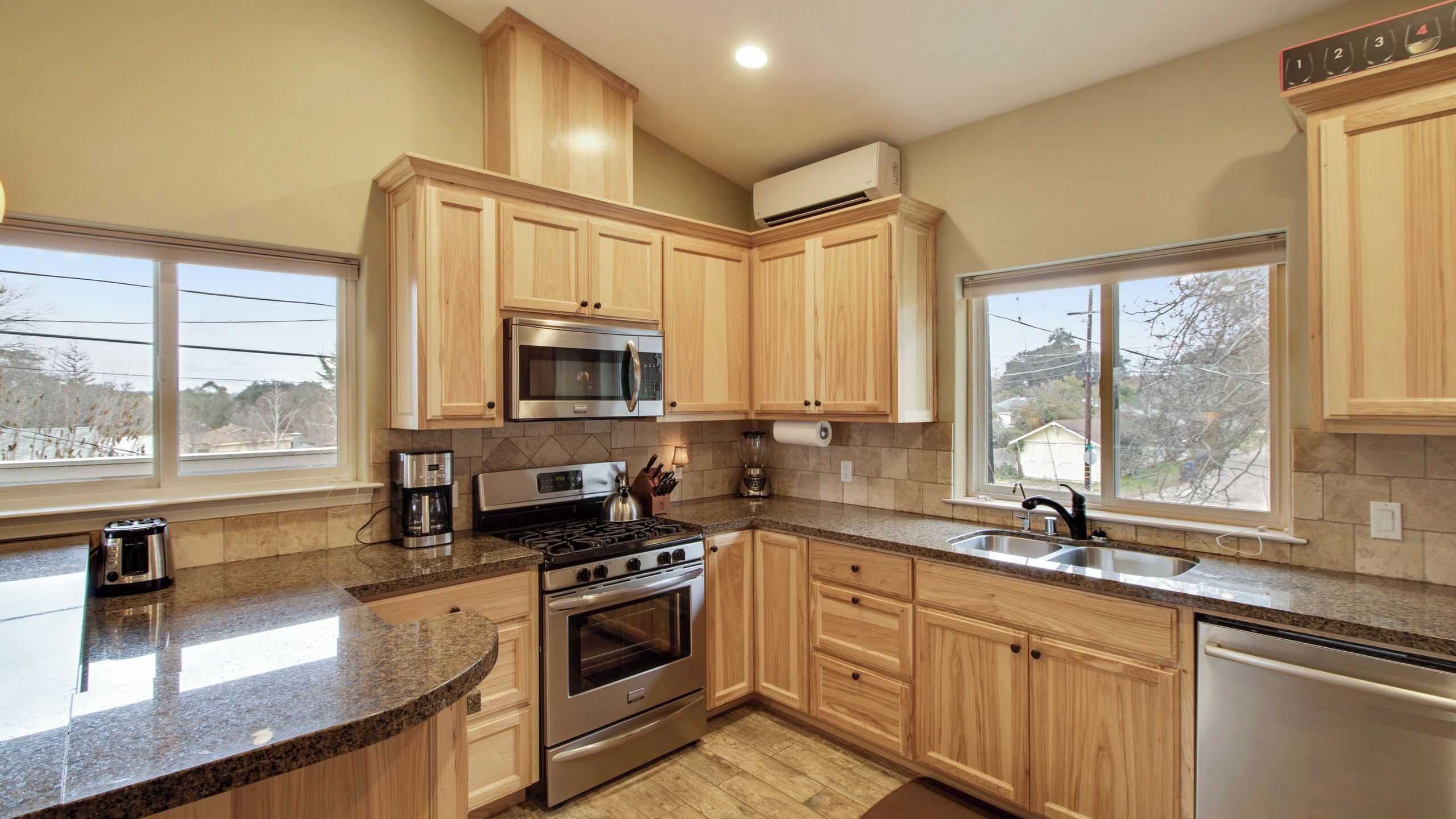 A kitchen with wooden cabinets, a stainless steel stove, a microwave, and a dishwasher.