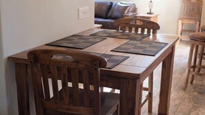 A wooden dining table with four chairs, each with a woven placemat. - Olive Alley by Avantstay Outdoor Dining + Full Kitchen Downtown Paso Robles Wine Country (Paso Robles)