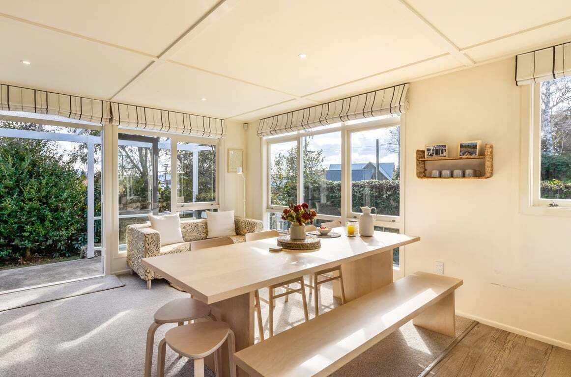 A spacious kitchen with a large island, ample natural light, and a view of greenery outside.