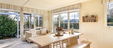 A spacious kitchen with a large island, ample natural light, and a view of greenery outside.
